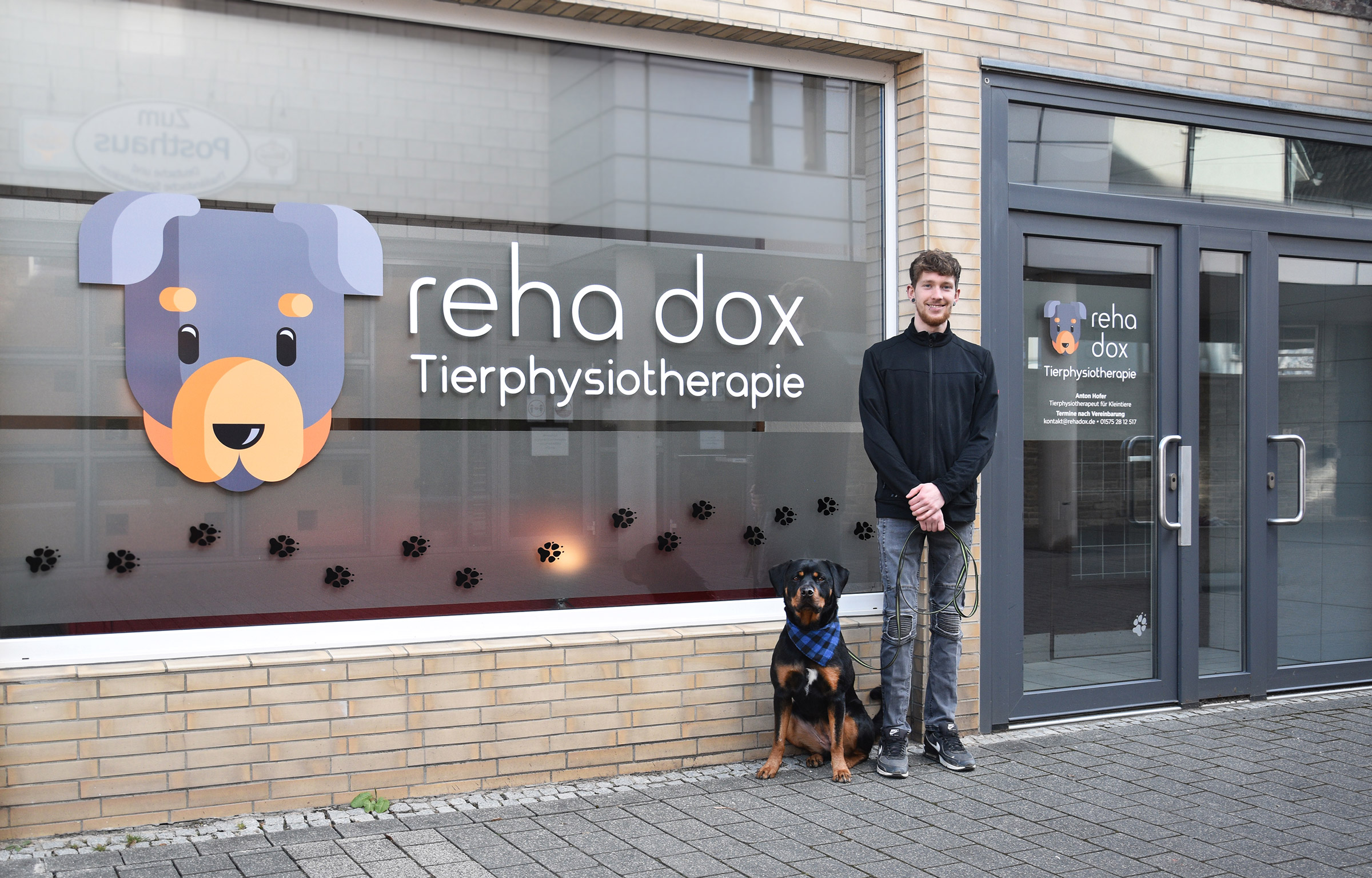 Anton Hofer mit seinem Hund vor dem Eingang zur Praxis für Tierphysiotherapie in Weilmünster